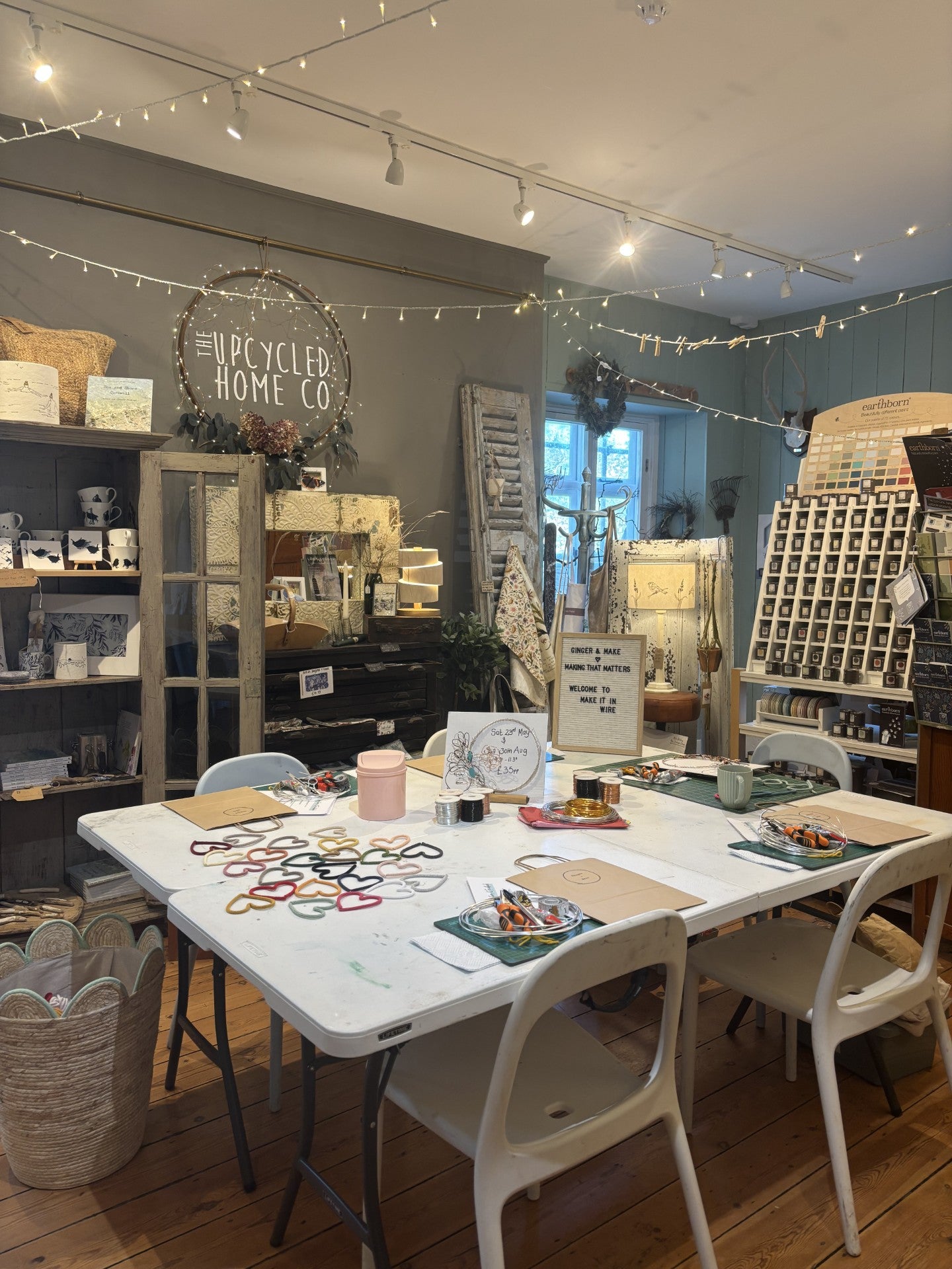 Workshop craft room with a table, chairs, and various items on display.