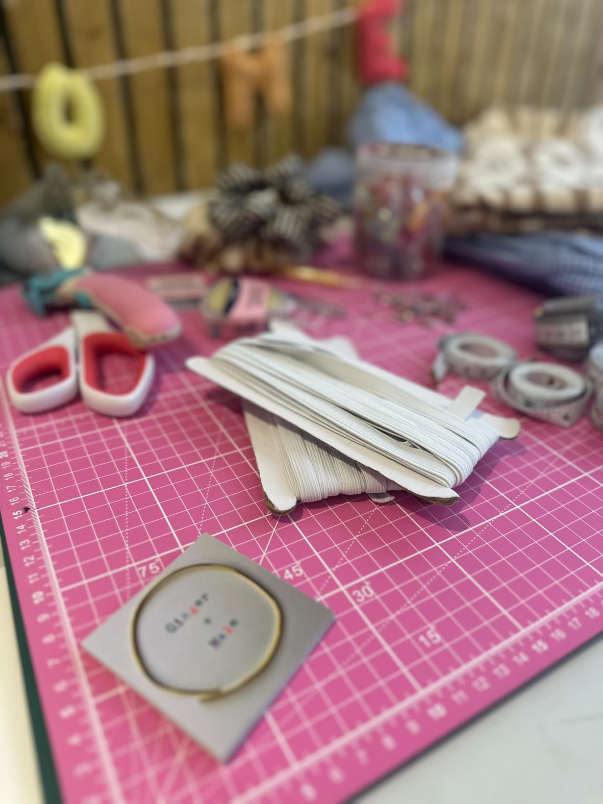 Crafting materials on a pink cutting mat with a grid pattern