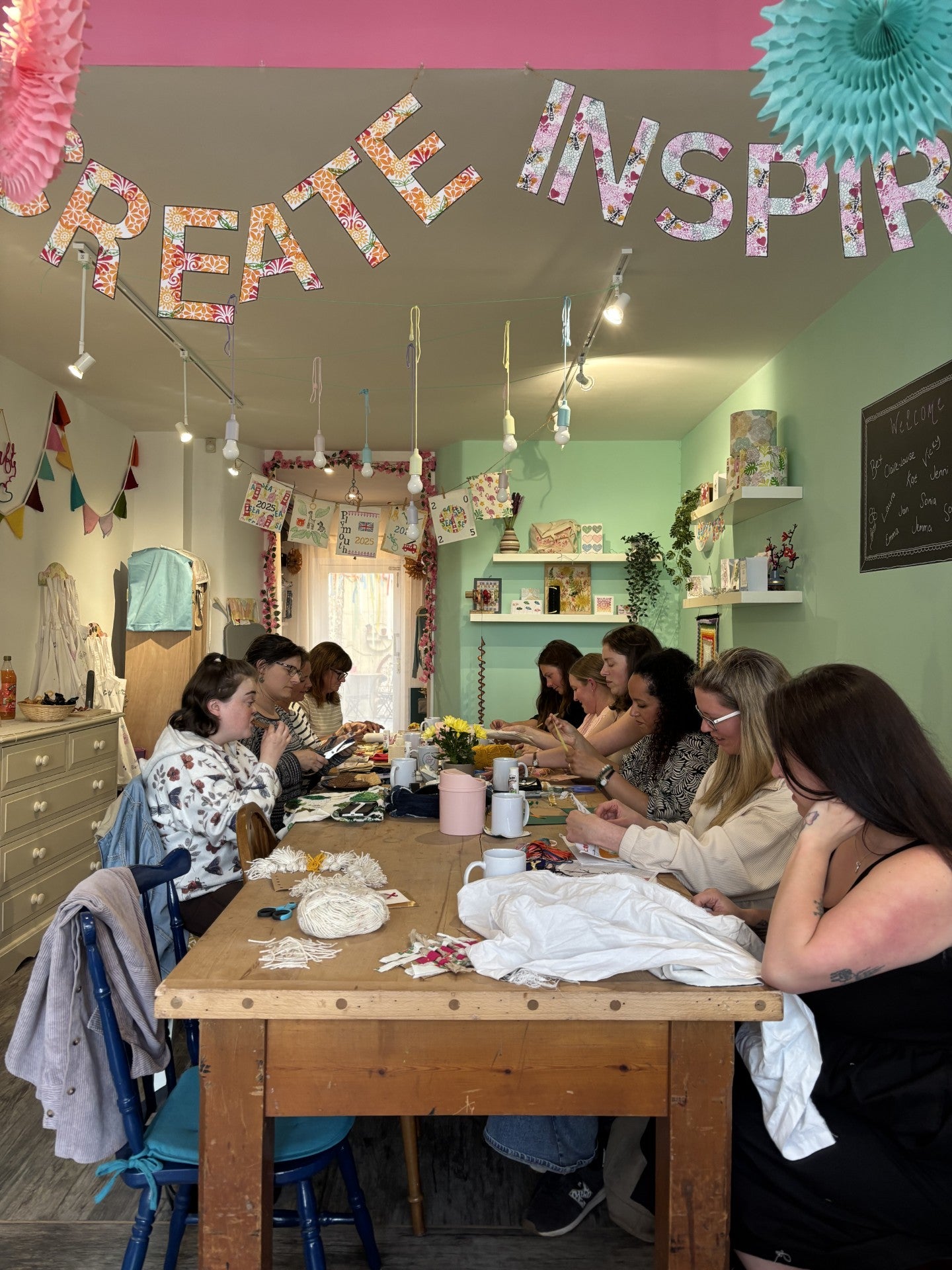 People taking part in Make Something Club making creative projects at a shared table 