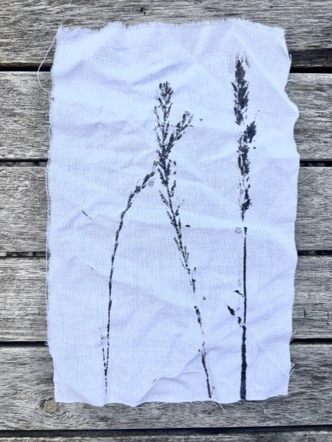 White fabric with black plant silhouette on a wooden surface