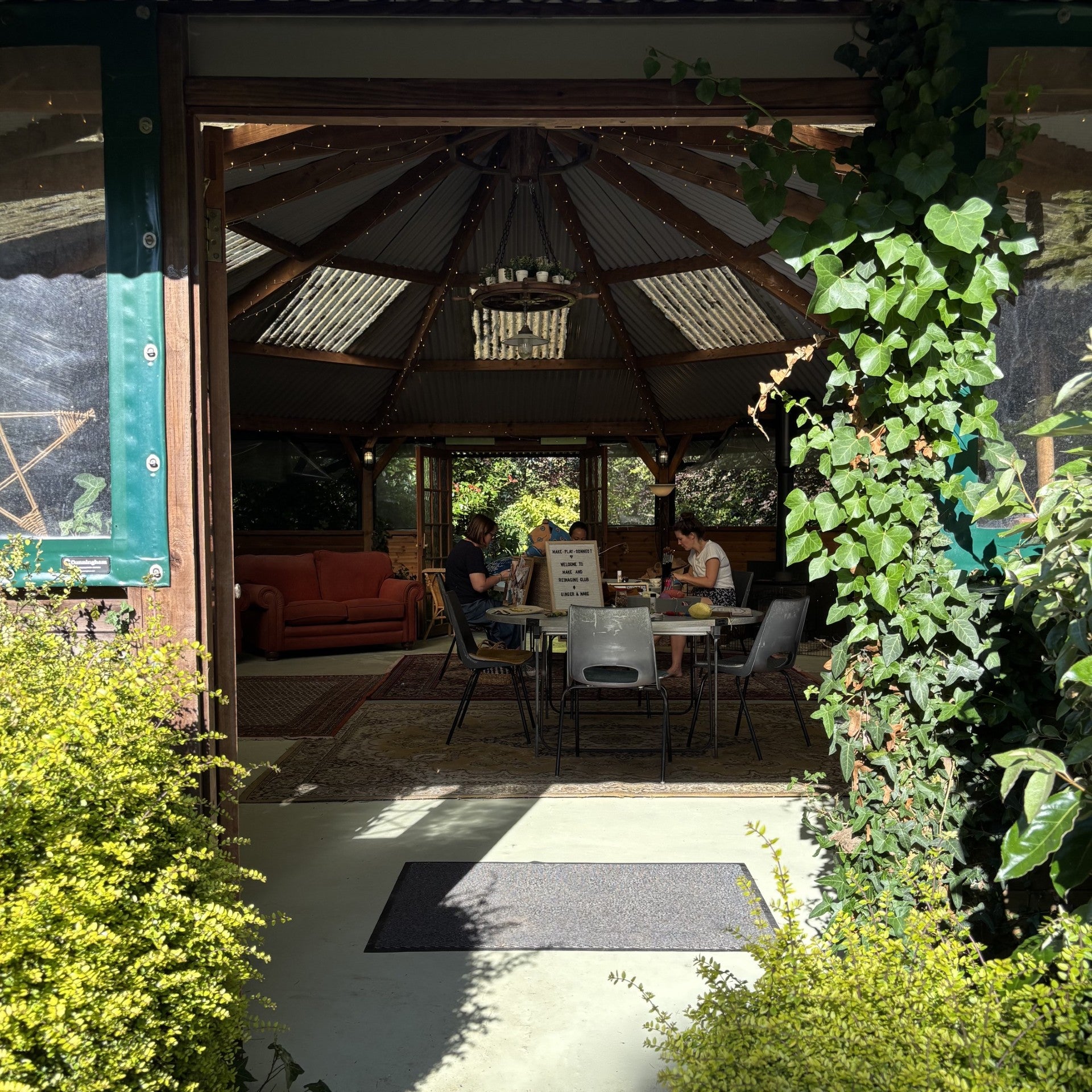 Indoor space with people sitting at a table, surrounded by greenery