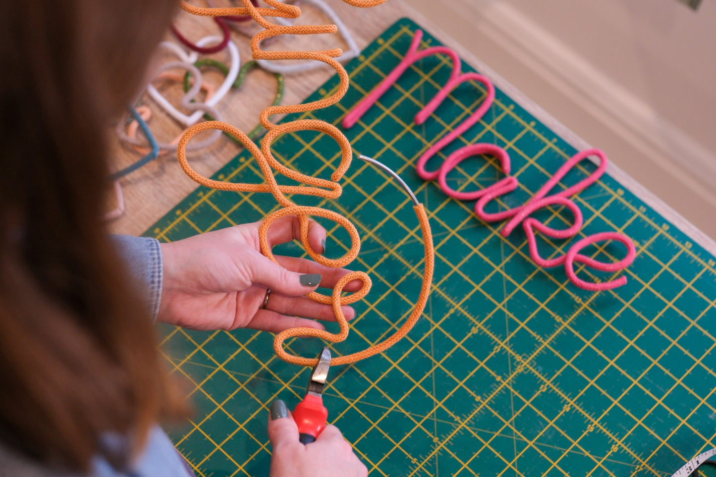 Person working with wire on a cutting mat 