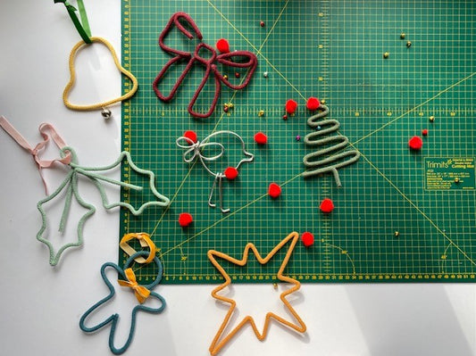 Colorful wire Christmas decorations on a green cutting mat